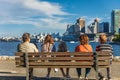 Rear view of family of five sitting on the bench in a city park. Three generations of family spending time together Royalty Free Stock Photo