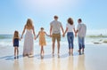 Rear view of family holding hands and having fun on a beach vacation together on a sunny day. Relatives enjoying summer Royalty Free Stock Photo