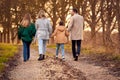 Rear View Of Family Holding Hands On Walk Through Autumn Countryside Together Royalty Free Stock Photo