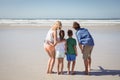 Rear view of family standing together at beach Royalty Free Stock Photo