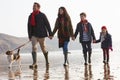 Rear View Of Family Walking Along Winter Beach With Dog Royalty Free Stock Photo