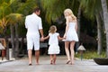 Rear View Of Family Walking On Wooden Jetty