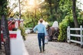 Rear view of farmer walking outdoors on small family farm. Royalty Free Stock Photo