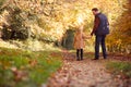 Rear View Of Father And Daughter Holding Hands On Family Walk Along Track In Autumn Countryside Royalty Free Stock Photo