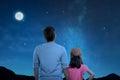 Rear view of father and little daughter looking at night scene Royalty Free Stock Photo