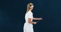 Rear view of female badminton player playing against blue background Royalty Free Stock Photo