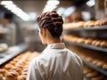 Rear view of female baker in bakery among the shelves with freshly baked bread, generative ai