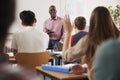 Rear View Of Female College Student Asking Question In Class Royalty Free Stock Photo