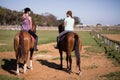 Rear view of female friends sitting on horse