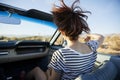 Rear View Of Female Passenger On Road Trip In Classic Convertible Car Royalty Free Stock Photo