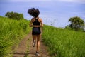 Rear view female runner training on countryside road - young attractive and fit jogger woman doing running workout outdoors at Royalty Free Stock Photo
