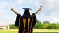 Rear view of a female university graduate stands and holds degree certificate to celebrate in the  graduation ceremony with clear Royalty Free Stock Photo