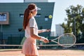 Rear view on forceful woman playing tennis in outdoor court, hitting ball, sport concept Royalty Free Stock Photo