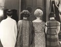 Rear view of four women standing in a row