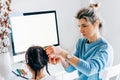 Rear view of a freelacer businesswoman using desktop computer in the office. Pretty young blonde woman sit indoors at home working Royalty Free Stock Photo