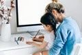 Rear view of a freelacer businesswoman using desktop computer in the office. Pretty young blonde woman sit indoors at home working Royalty Free Stock Photo