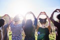 Rear view of friends making a heart with hands