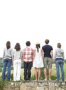 Rear View of Friends Standing on Stone Wall