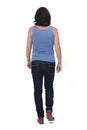 Rear view of a full portrait of a woman walking and with casual clothes on white background Royalty Free Stock Photo