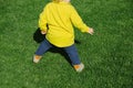 Rear view of funny toddler playing soccer football in green lawn Royalty Free Stock Photo