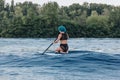 rear view of girl with blue hair sitting on paddle board