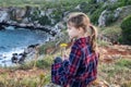 Girl sitting at a picturesque rocky coastline Royalty Free Stock Photo