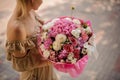 Rear view of girl who holds huge bouquet of different flowers