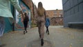 Rear view of girls in trendy, fashionable clothes walking on the street back view. Girls friends walk . Girl walking the