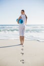 Rear view of gorgeous woman holding exercise mat looking over sh Royalty Free Stock Photo