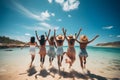 Rear view of group of cheerful happy young woman friends having fun at the beach, walking along the seashore on a beautiful summer Royalty Free Stock Photo