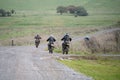 Rear view of a group of cyclists riding their off-road bikes along a stone track