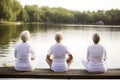 rear view of group of senior women doing yoga exercises on wooden pier in front of summer morning lake, neural network Royalty Free Stock Photo