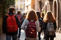 Rear view of a group of students with backpacks walking on the street, Back view of a group of students with backpacks walking on