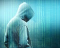 Rear view of hacker in black hoodie standing with binary code