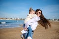 Rear view of a happy mother giving piggyback ride to her lovely daughter at beach. Royalty Free Stock Photo