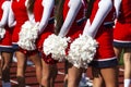 Rear view of cheerleaders with their red and white pom poms behind them
