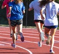 Rear view of high school girls running in a group on a track Royalty Free Stock Photo