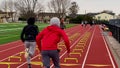 Runners running over six inch hurdles in lane on a track