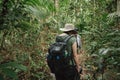 Hiker woman with backpack walking on path in summer forest. Royalty Free Stock Photo