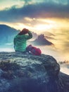 Rear view of hiker woman on top of mountain peak in rocks