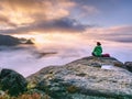 Rear view of hiker woman on top of mountain peak in rocks