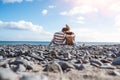 Rear view of hugging couple sitting on natural pebble beach Royalty Free Stock Photo