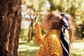 Rear view image of cute little girl exploring the nature with magnifying glass outdoor. Child playing in the forest with Royalty Free Stock Photo