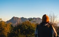 A female traveler sitting on folding chair, watching mountain view and and sunrise in the morning