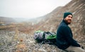 Rear view image of happy hiker young man in green hat, feel good after hiking in mountains. Royalty Free Stock Photo