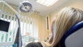 Rear view closeup image of young blonde woman lying in dentist chair