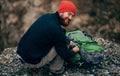 Rear view image of young hiker man relaxing in mountains after hiking. Outdoors shot of traveler male in red hat Royalty Free Stock Photo