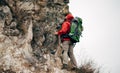 Rear view image of young man hiking in mountains dressed in red clothes exploring new places. Royalty Free Stock Photo