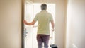 Rear view image of young tourist man walking in hotel room Royalty Free Stock Photo