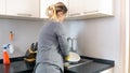 Rear view photo of young woman washing dishes in kitchen sink Royalty Free Stock Photo